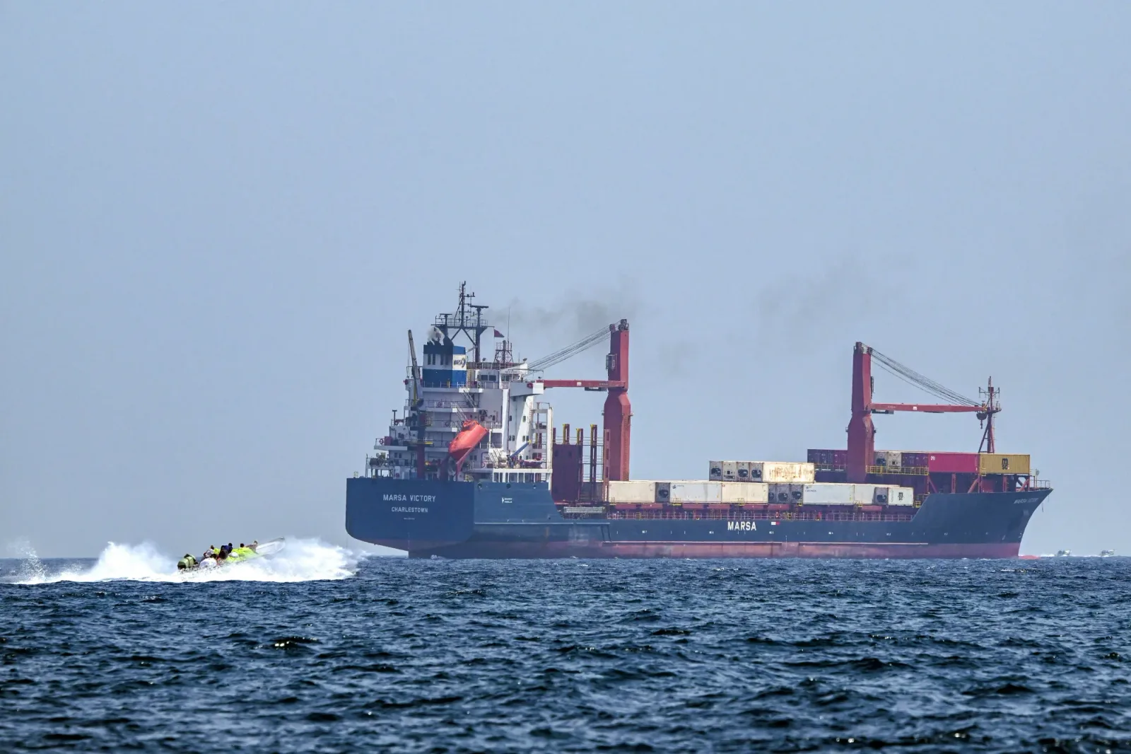 Vapor de marfă navigând pe marea calmă, cu un alt vas în apropiere.
