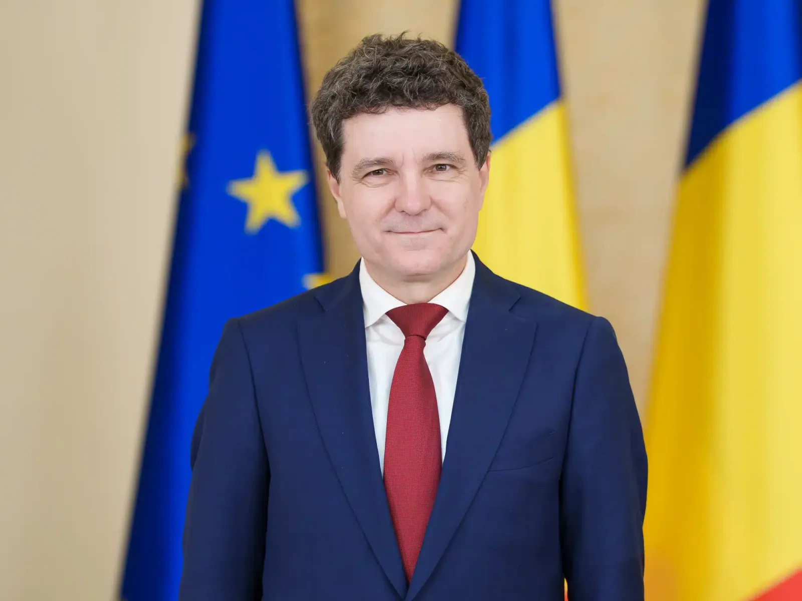Președintele Nicușor Dan în fața drapelului României și Uniunii Europene.