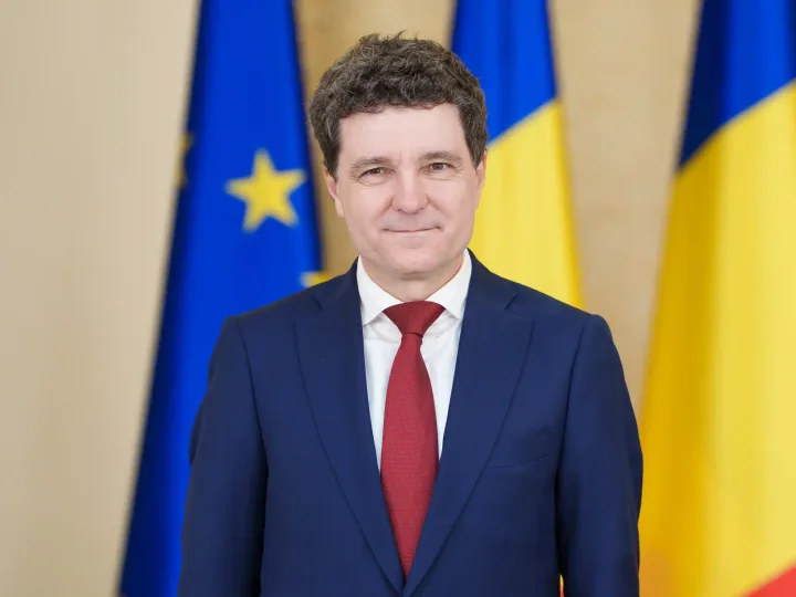 Președintele Nicușor Dan în fața drapelului României și Uniunii Europene.