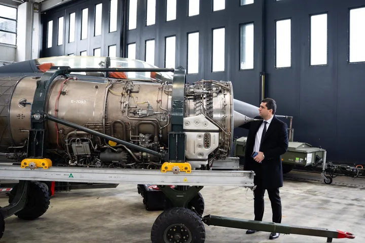 Un bărbat inspectează un motor de avion într-un atelier tehnic.