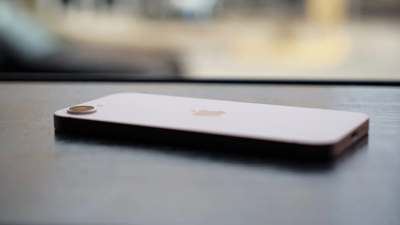 Un telefon Apple așezat pe o masă, cu un fundal neclar.