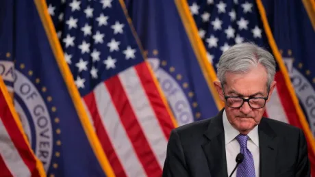 Șeful Fed, Jerome Powell, în fața steagurilor americane.