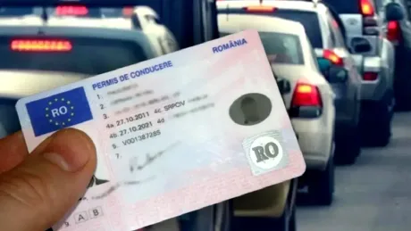 Permis de conducere românesc, cu detalii vizibile, în context urban aglomerat.