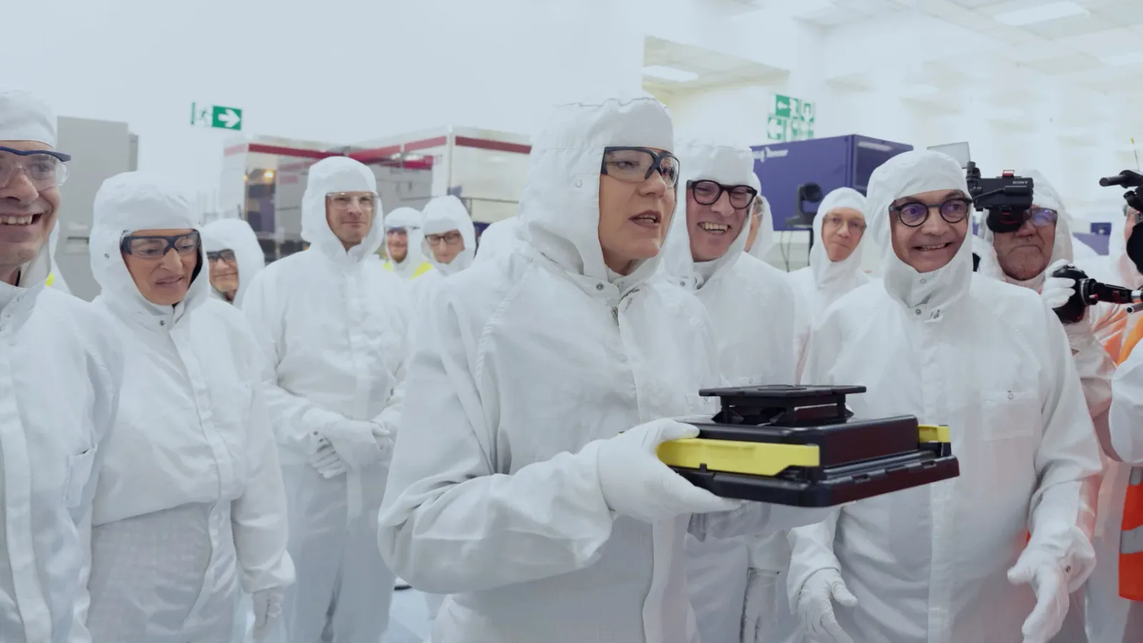 Grup de oameni în echipamente de protecție într-o fabrică de cipuri.