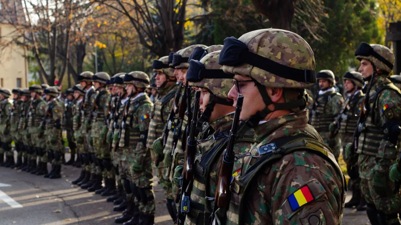 Soldați români în uniformă, pregătiți pentru o ceremonie militară.