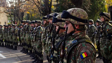 Soldați români în uniformă, pregătiți pentru o ceremonie militară.