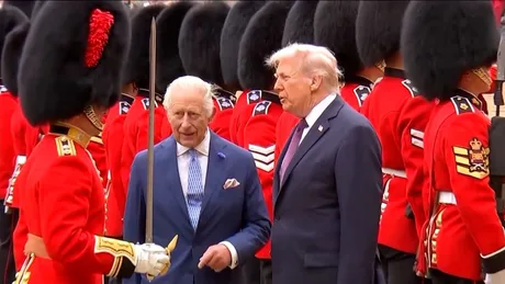 Regele Charles și Donald Trump discutând în fața unei gărzi ceremoniale.