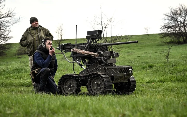Doi soldați operând un robot militar pe un câmp verde.