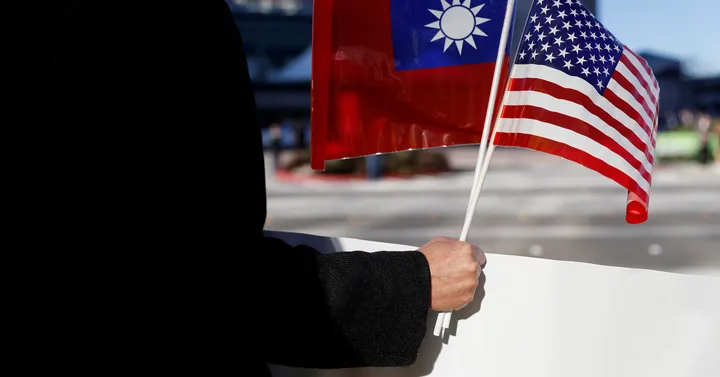 Un bărbat ține steagurile Taiwanului și SUA, simbolizând relațiile internaționale.