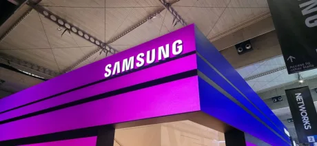 Logo-ul Samsung expus la un eveniment tehnologic, cu iluminare violet.