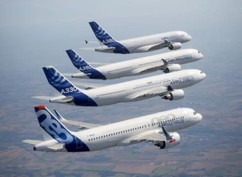 Patru avioane Airbus zburând în formație pe un fundal de cer senin.
