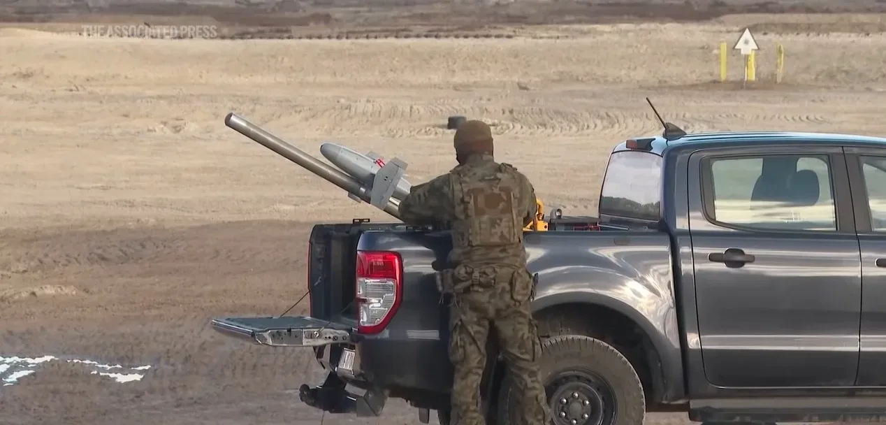 Soldat pregătind un sistem anti-dronă pe un vehicul.