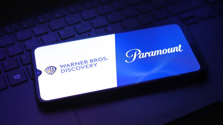 Logo-urile Warner Bros. Discovery și Paramount pe un ecran de telefon.
