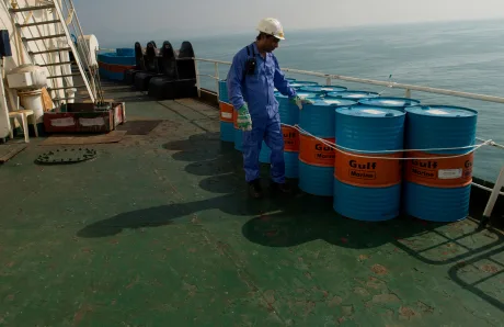 Barili de petrol pe o platformă maritimă, pregătiți pentru transport.