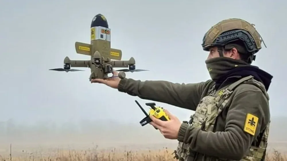 Un soldat lansează o dronă pe câmpul de luptă, pregătit pentru misiune.