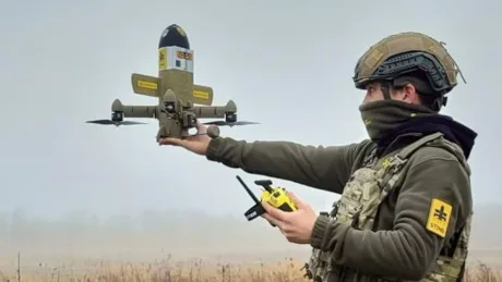 Un soldat lansează o dronă pe câmpul de luptă, pregătit pentru misiune.