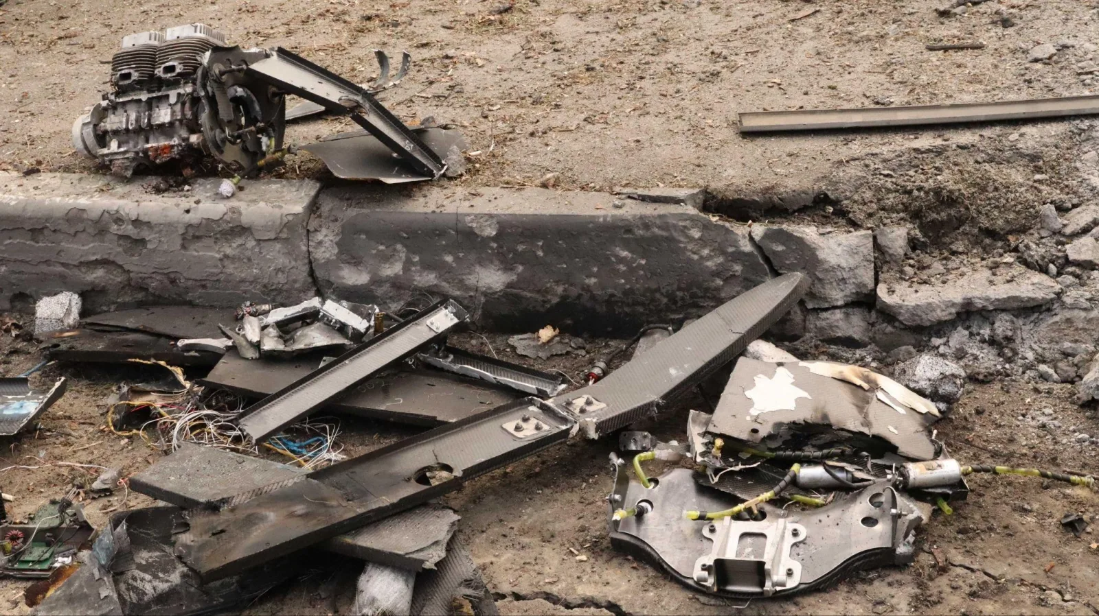 Resturi de drone distruse pe un teren afectat de atacuri aeriene.