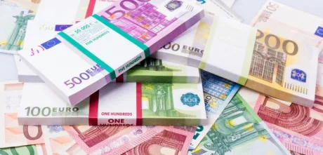 Bancnote euro și monede pe un fundal alb.