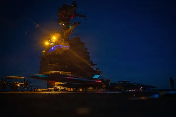 Distrugător american în noapte, cu lumini strălucitoare pe punte.