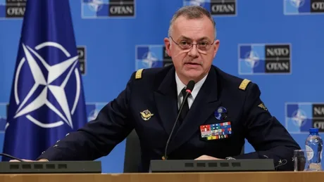 Oficial NATO discutând despre necesitatea adaptării armamentului în fața amenințărilor moderne.