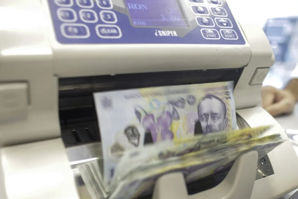 Bancnote românești în proces de verificare la un aparat specializat.