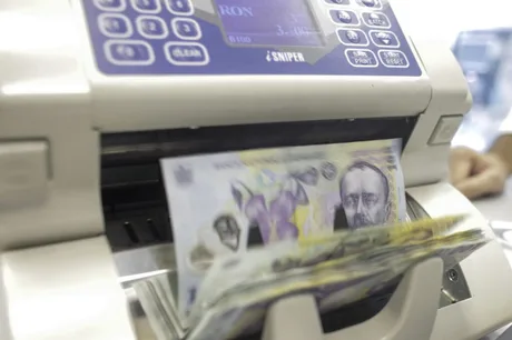 Bancnote românești în proces de verificare la un aparat specializat.
