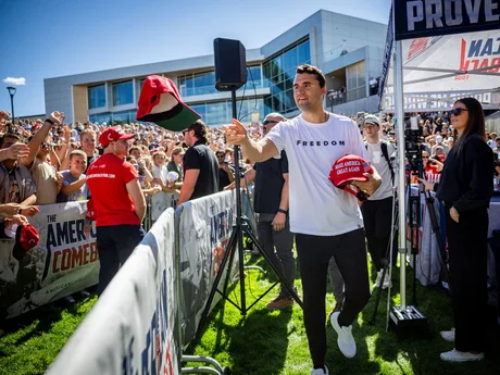 O mulțime de susținători la un eveniment public, cu Charlie Kirk în prim-plan.