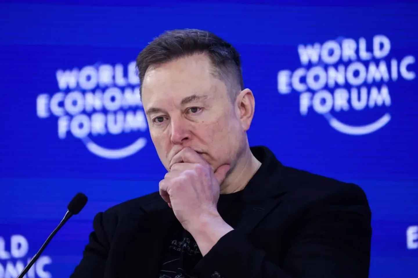 Elon Musk reflectând asupra unei situații legale complexe în cadrul unui forum economic.