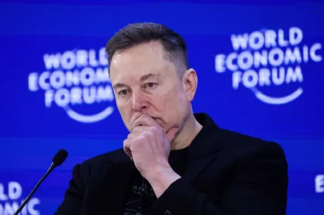 Elon Musk reflectând asupra unei situații legale complexe în cadrul unui forum economic.