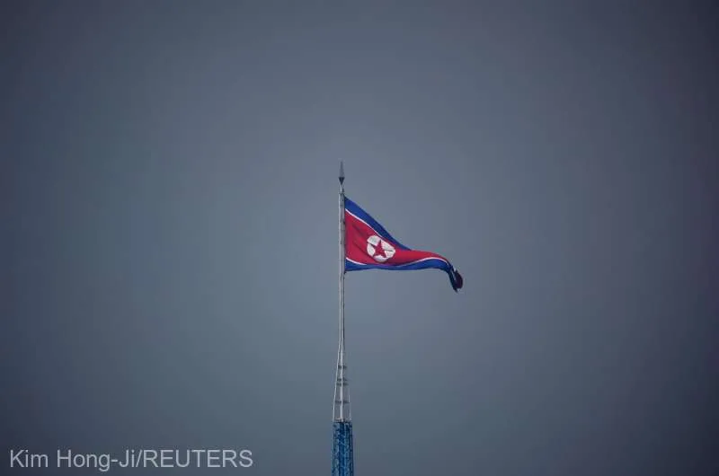 Steagul Coreei de Nord fluturând pe un catarg în condiții de vreme mohorâtă.