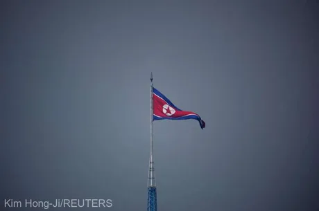 Steagul Coreei de Nord fluturând pe un catarg în condiții de vreme mohorâtă.