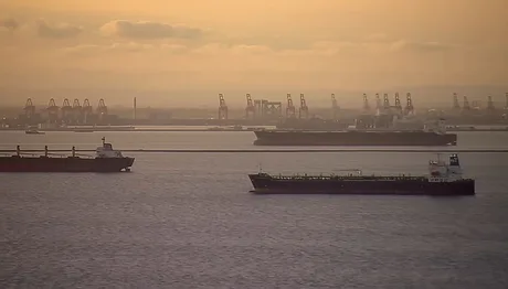 Nave de transport maritim pe fundalul unui apus de soare.