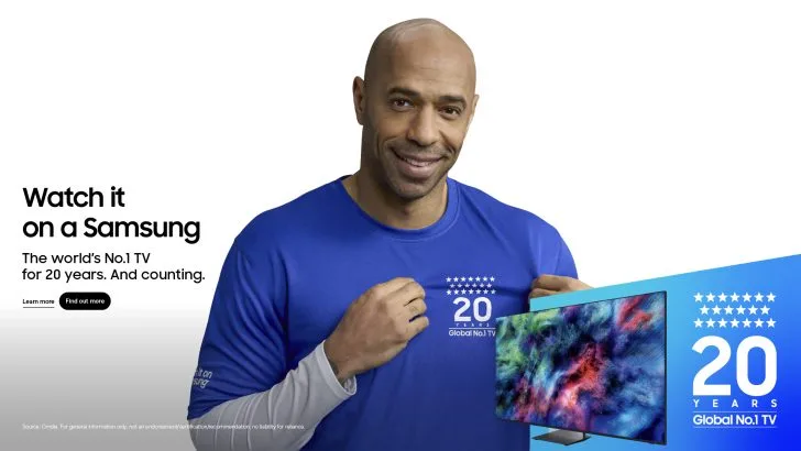 Un bărbat zâmbitor poartă un tricou cu un mesaj despre televizoare Samsung.