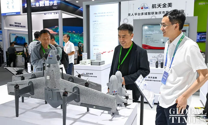 Vizitatori admirând tehnologia militară avansată la expoziția din Beijing.