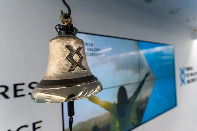 Clopotul de la bursă simbolizează tranzacțiile financiare importante.