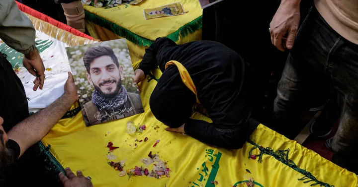 Un copil plânge lângă o fotografie a unui luptător Hezbollah decedat.