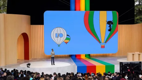 Prezentare pe scenă cu baloane colorate și logo I/O.