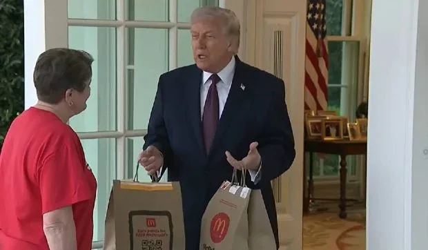 Donald Trump interacționează cu o livratoare de la McDonald’s la Casa Albă.