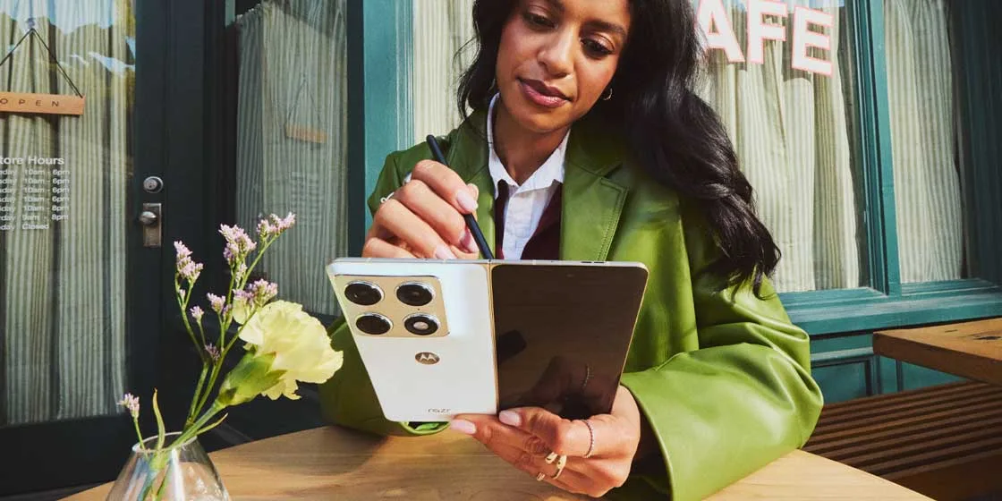 Un telefon pliabil Motorola Razr Fold utilizat cu un stylus pe o masă.