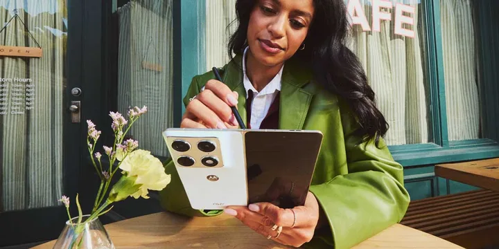 Un telefon pliabil Motorola Razr Fold utilizat cu un stylus pe o masă.