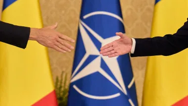 Mâini întinse în semn de colaborare între România și NATO.