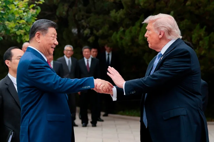 Xi Jinping și un oficial american se salută într-un cadru diplomatic.