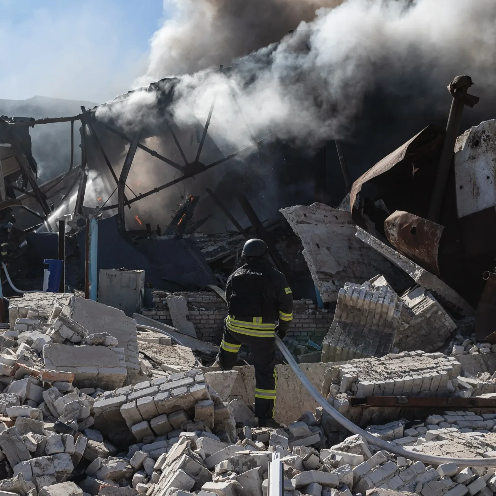 Un pompier inspectează ruinele unui edificiu distrus de atacuri aeriene.