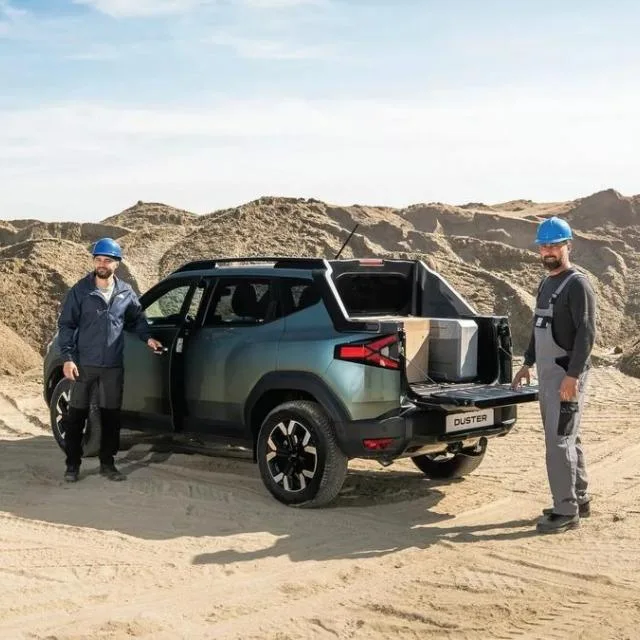 Duster Pick-Up, vehicul utilitar pentru transport marfă, pe un teren de nisip.