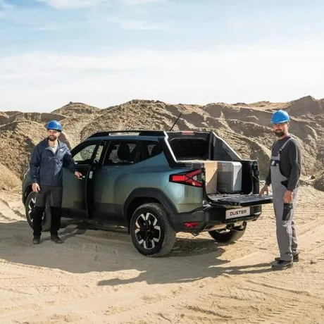 Duster Pick-Up, vehicul utilitar pentru transport marfă, pe un teren de nisip.