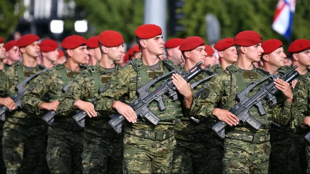 Recruți croați în timpul instruirii militare, purtând uniforme și berete roșii.