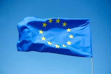 Steag al Uniunii Europene fluturând pe un fundal albastru.