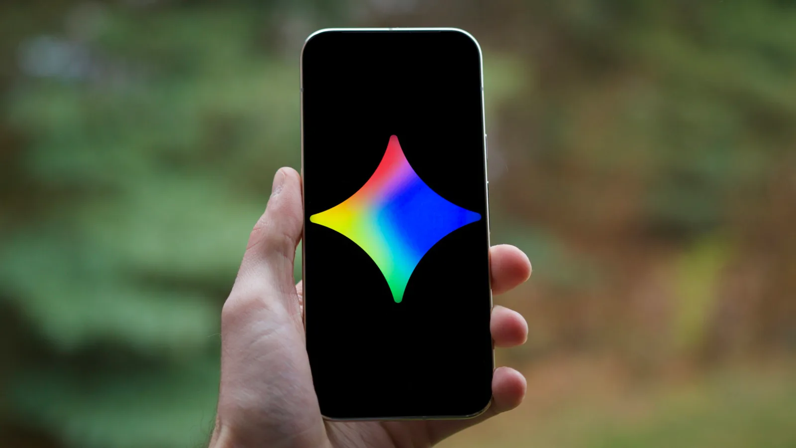Un telefon mobil cu un logo colorat pe ecran, în natură.