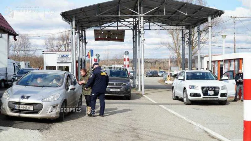 Punct de frontieră cu vehicule și autorități vamale în acțiune.