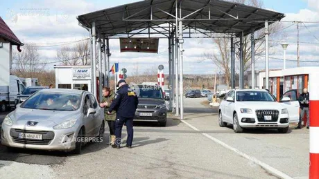Punct de frontieră cu vehicule și autorități vamale în acțiune.